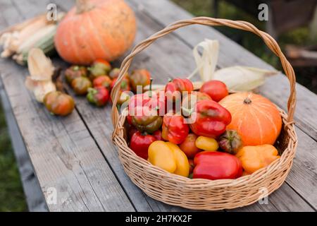 Fresh vegetables in basket on wooden table Stock Photo