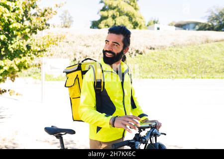 Delivery man using city map on mobile phone Stock Photo