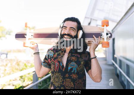 Man with prosthetic leg using mobile phone on boardwalk Stock Photo