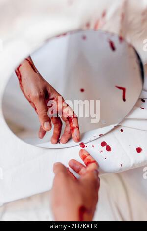 Reflection of bleeding hand on mirror Stock Photo