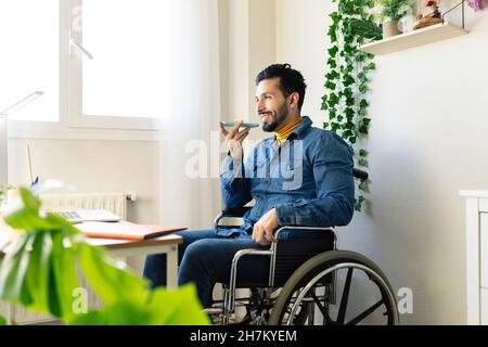Disabled businessman working on laptop at home Stock Photo