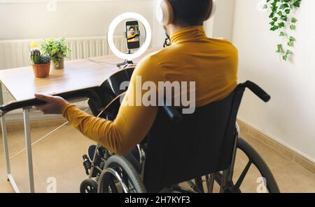 Smiling male influencer playing guitar on wheelchair Stock Photo