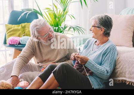Senior couple with knitting needle sitting in living room Stock Photo