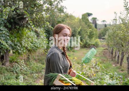 Smiling female farmer looking down in garden Stock Photo