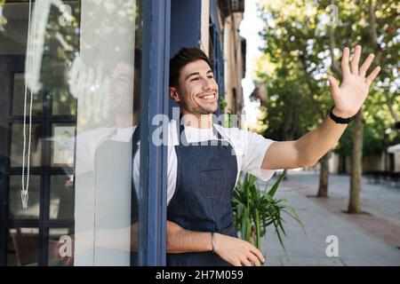 Smiling owner with arms crossed standing in cafe Stock Photo