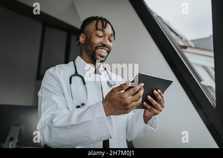 Smiling doctor using tablet PC in office Stock Photo