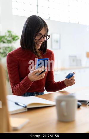 Working woman holding credit card and smart phone Stock Photo