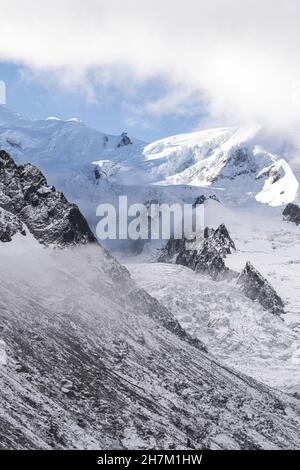 Smiling man hiking wearing warm clothes on snow Stock Photo