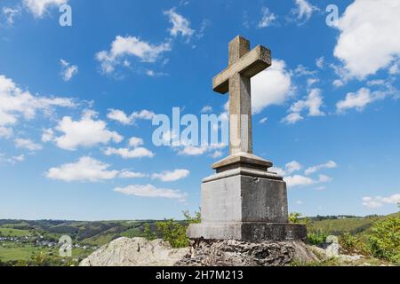Man sitting by Summit Cross on sunny day, Simmerath, Eifel, North Rhine Westphalia, Germany Stock Photo