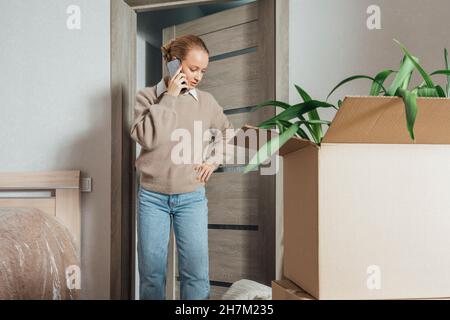 Woman talking on smart phone in new apartment Stock Photo