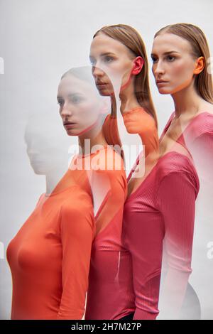Multiple exposure of twin sisters by white background Stock Photo