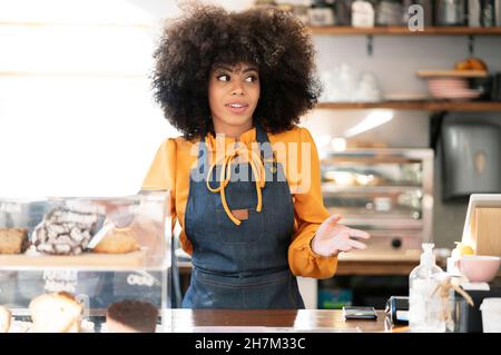 Businesswoman with laptop talking on mobile phone at cafe window Stock Photo