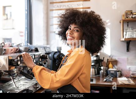 Smiling waitress showing check mark card reader screen in cafe