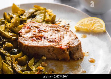 Plate of stuffed pork loin with lemon zucchini salad served on table Stock Photo
