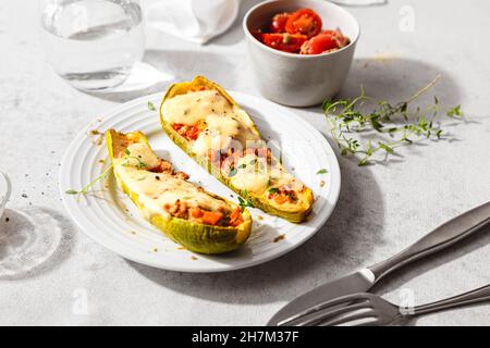 Fresh stuffed zucchini with cherry tomatoes and cheese in plate Stock Photo