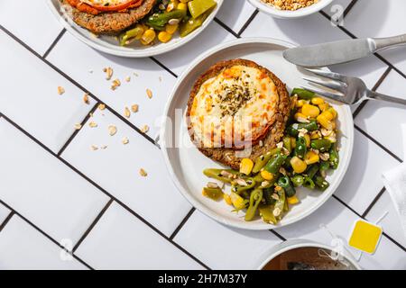 Marinated chicken with quinoa and vegetables in plate by napkin Stock Photo