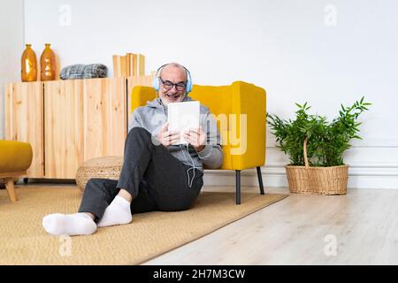 Man with headphones using mobile phone at home Stock Photo