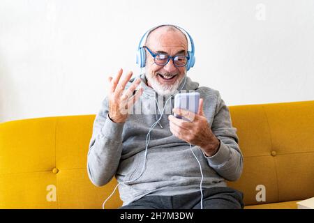 Smiling senior man drinking coffee on sofa Stock Photo