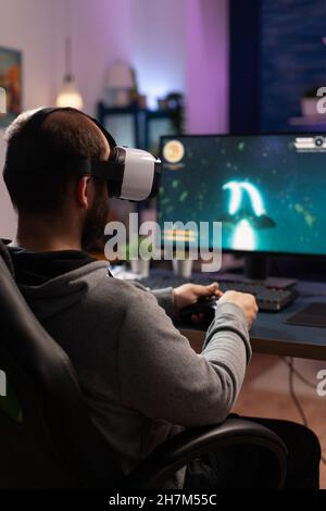 Free Photo  Person playing video games with controller on computer. player  using joystick and wearing headphones to play online game on monitor.  modern man using gaming equipment to have fun.