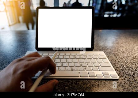 Blank screen laptop computer modern man use room laptop with blank white desktop screen with coffee cup on wooden table in cafe Stock Photo