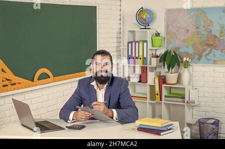 Work for Success. college lecturer on lesson. back to school. formal education. cheerful mature teacher making notes in paper. brutal bearded man work Stock Photo