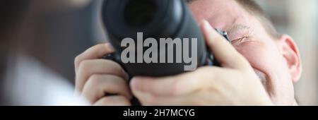Man photographing woman using black professional camera Stock Photo