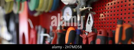 Many working tools hanging on wall in workshop closeup Stock Photo