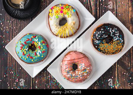 Delicious donuts decorated with different decorations on wooden table Stock Photo
