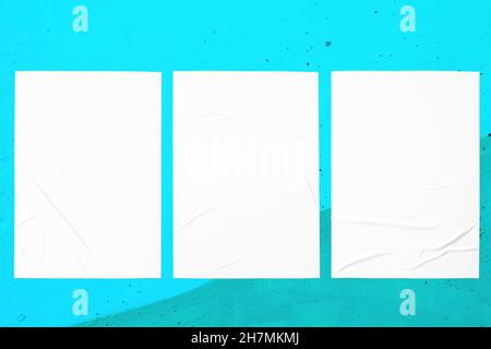teal mint urban wall with three glued posters Stock Photo