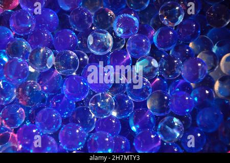 Navy blue water gel bubbles balls background.Transparent blue hydrogel balls. Blue water gel balls with bokeh. Polymer gel Silica gel. Liquid crystal