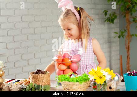 Happy little girl with bunny ears getting ready for Easter party Stock Photo