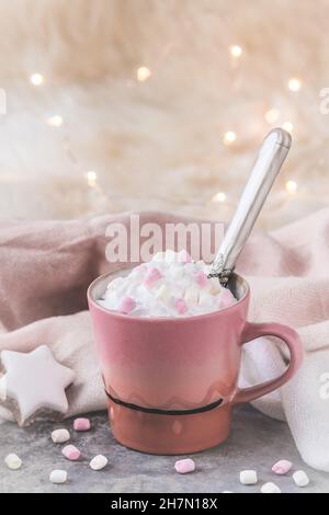Cup of coffee or hot chocolate with cream and marshmallows, fairy light in the background, vertical with copy space Stock Photo