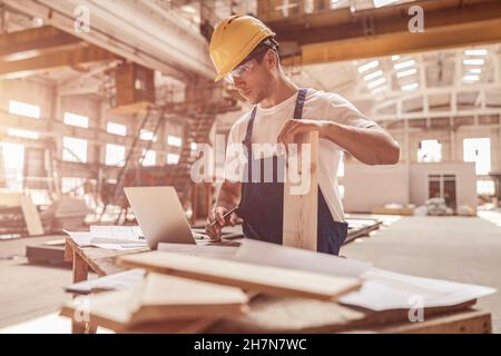 Handsome man builder using notebook at construction site Stock Photo