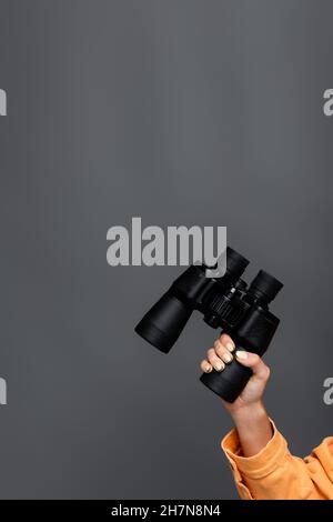 Cropped view of tourist holding binoculars isolated on grey Stock Photo