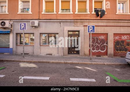 Lower part of the facade of a building with parking for disabled persons on the street Stock Photo
