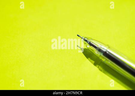 Ball pen on a bright green paper. Copy space. Stock Photo