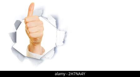 Young woman showing thumbs up through hole in paper as business success concept Stock Photo