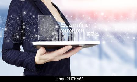 Cyber security and data protection. Hand hold white tablet with digital hologram fingerprint sign on light blurred background. Fingerprint scanning of Stock Photo