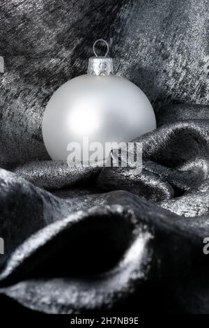 White Christmas bauble on silver background with copy space for text. Christmas card or new year card design. Stock Photo