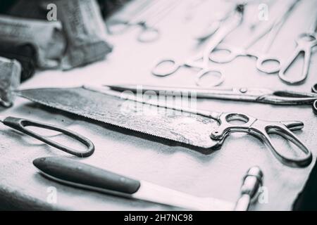 Old Medical And Surgical Instruments. Many Old Surgical Instruments For Surgery. Black And White Toned Shot. Old Different Metal Medical Instruments Stock Photo