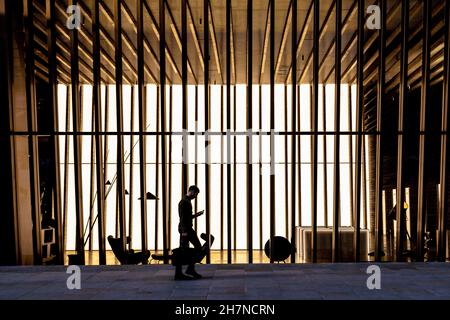 Man walking in front of a contemporary office building, looking at phone (70 St Mary Axe, London, UK) Stock Photo