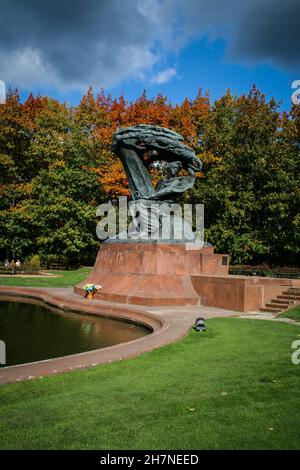 Fryderyk Chopin monument in Lazienki city park in Warsaw, Poland, in sunny fall day with trees in background in autumn colour leaves Stock Photo