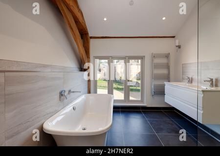 Chishill, Hertfordshire - November 13 2019: Newly fitted modern bathroom suite contrasting traditional setting with exposed timbers and beams inside r Stock Photo