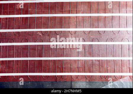 Process of instalation of electric underfloor heating mats Stock Photo