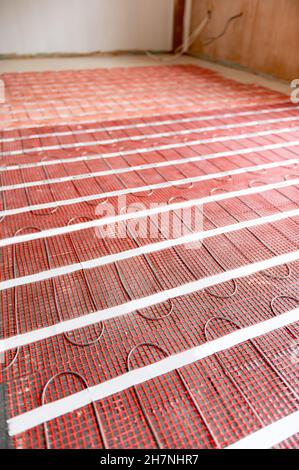 Process of instalation of electric underfloor heating mats Stock Photo