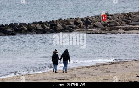 24 November 2021, Mecklenburg-Western Pomerania, Kühlungsborn: Two walkers are on the almost deserted beach. Many clouds and drizzle provide classic North German dirty weather. Photo: Bernd Wüstneck/dpa-Zentralbild/ZB Stock Photo