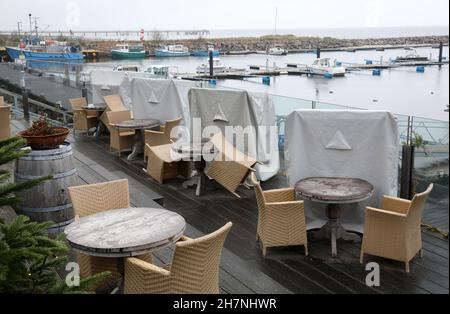 24 November 2021, Mecklenburg-Western Pomerania, Kühlungsborn: Weatherproof packed like at the last Corona Lockdown are the beach chairs in the outdoor area of a restaurant in the boat harbour. Many clouds and drizzle provide classic North German dirty weather. Photo: Bernd Wüstneck/dpa-Zentralbild/ZB Stock Photo