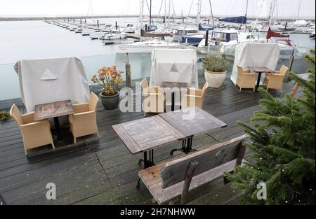 24 November 2021, Mecklenburg-Western Pomerania, Kühlungsborn: Weatherproof packed like at the last Corona Lockdown are the beach chairs in the outdoor area of a restaurant in the boat harbour. Many clouds and drizzle provide classic North German dirty weather. Photo: Bernd Wüstneck/dpa-Zentralbild/ZB Stock Photo