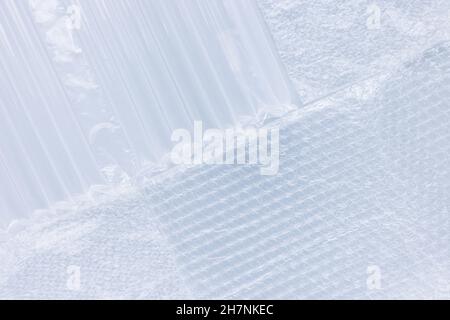 Variety of bubble wrap foil for packaging on light blue background. Closeup, texture background, plastic pollution concept Stock Photo
