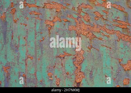 Rusted metal wall with layers of peeling paint. Backgrounds and textures. Stock Photo